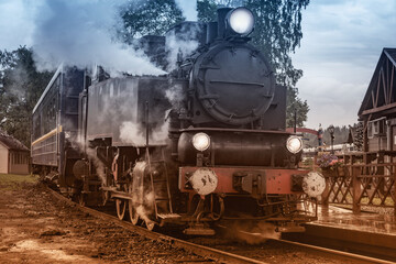 Retro steam train arrives to the platform.