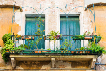 Fototapeta na wymiar Windows with flowers in old house in Venice
