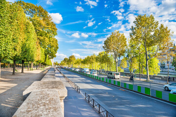 Street with many cars near green park at european city. Paris, France