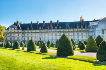 Park with green lawn and trimmed bushes at entrance of Les Invalides. Paris, France