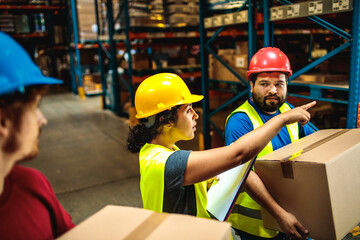 Workers in safety gear checking inventory in warehouse