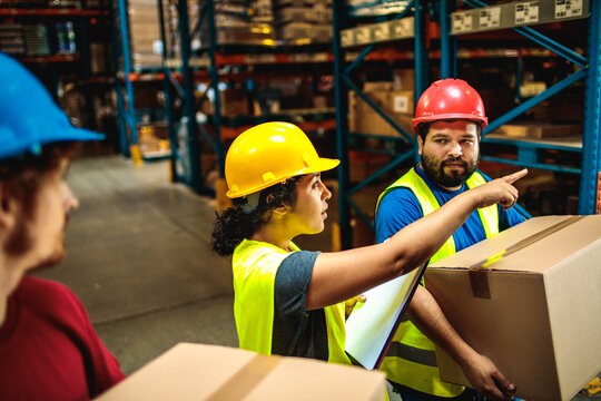 Workers in safety gear checking inventory in warehouse