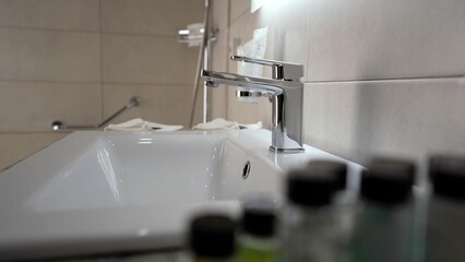 Close-up of a stylish bathroom with a black faucet, round mirror and white sink. White sink in the...