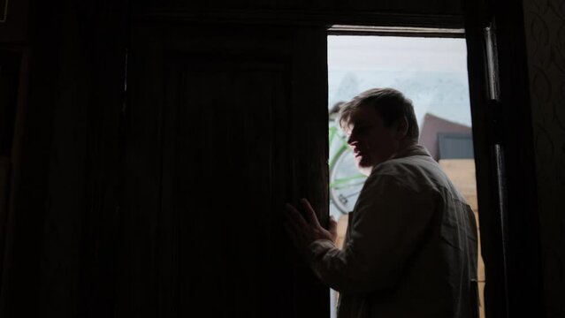 A man collects old things in a box to move from his old house. He leaves his old apartment and is sad