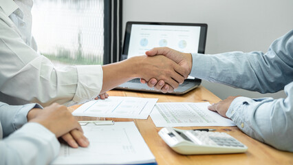 Asian couple shaking hands with financial advisor after consultation for investment of new business - obrazy, fototapety, plakaty