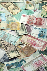 Many banknotes of different currency. Background of big amount of random money bills close up