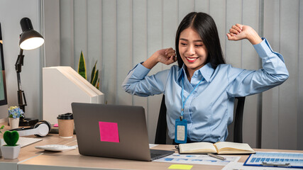 Secretary woman is raising arms to stretching for relaxing after sitting to work hard about summary of business