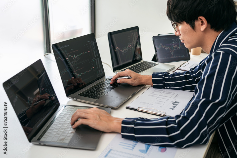 Poster Business man trader using laptop to checking stock market online and looking statistics graph on laptop to analyze