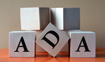 ADA - acronym on large wooden cubes on light brown background - obrazy, fototapety, plakaty