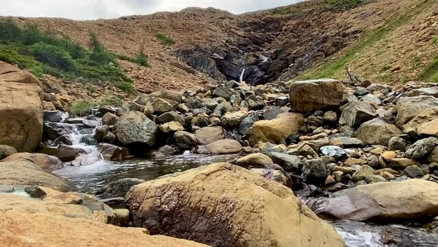 Tablelands in Gros Morne National Park, a Canadian national park and World Heritage Site in Newfoundland. An area where earth's mantle is exposed, peridotite rocks rich with iron rust, waterfall.
