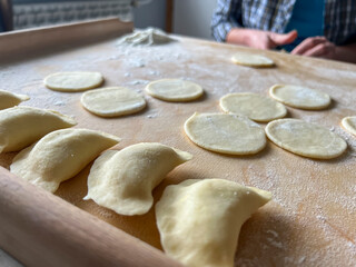 Home-made dumplings, kneading the dough by hand, rolling it, cutting it out and gluing it together