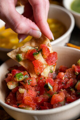 Woman dips chip in salsa