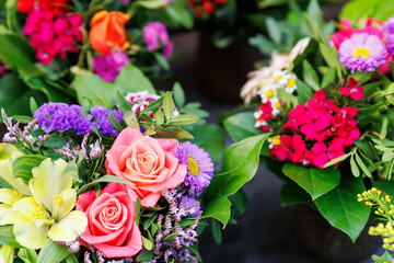 Many colorful array of fresh flower bouquets on display at an outdoor street city market on warm spring sunny day. Bright blossoming plants retail store at Bremen Germany