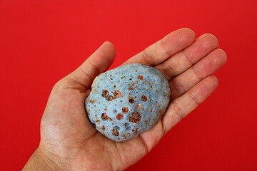 a natural stone resembling a meteorite in a man's hand © Abdulkadir