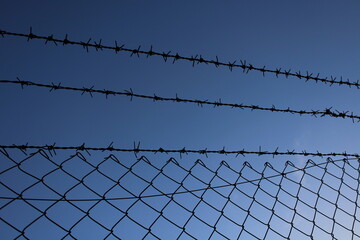 barbed wire fence in the field.symbol of freedom. blue sky in the background 