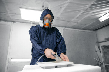 Professional worker Painter staining wood furniture with spray gun. Concept industry carpentry...