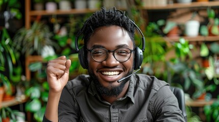 Cheerful man with headset on call in a green indoor space.