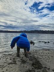 Child playing by shore of lake Washington. 