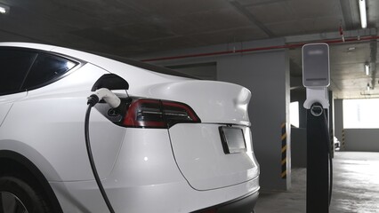 EV electric car recharge at shopping center multistorey indoor parking lot charging in downtown...