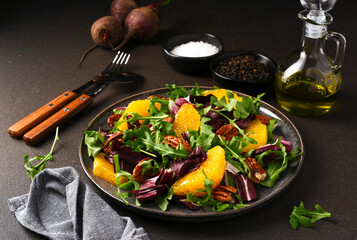 Arugula, orange and pecan salad. Radicchio salad on brown background - 752525392