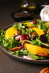 Arugula, orange and pecan salad. Radicchio salad on brown background - 752525963