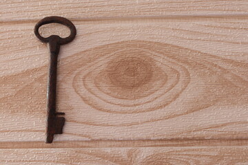 llave  grande antigua sobre madera fondo claro 