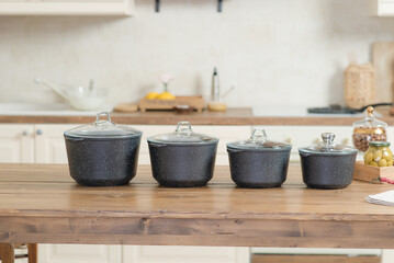 A set of four cast iron pans stands on the kitchen table