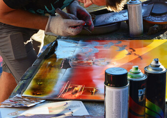 artysta uliczny malujacy obraz kolorowym sprayem, street artist painting a picture with colorful spray, brushes and tools on the sidewalk	
 - obrazy, fototapety, plakaty