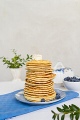 Stack of freshly prepared pancakes on a plate in a bright kitchen