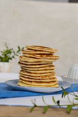 Stack of freshly prepared pancakes on a plate in a bright kitchen