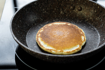The process of frying pancake in a frying pan