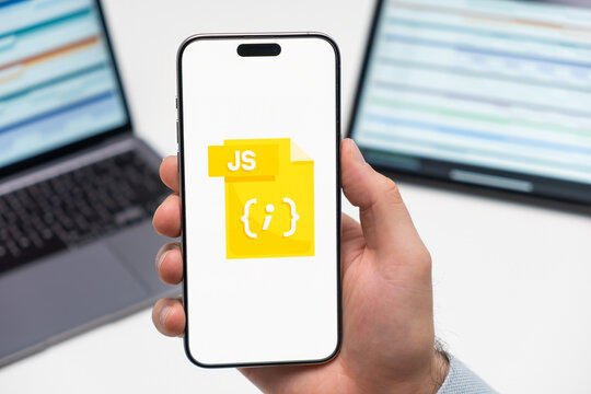 PRAGUE, CZECH REPUBLIC - JANUARY 21 2024: JS logo on the screen of smartphone in mans hand on the workplace background. 
