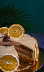 Cutaway orange cake with cream on a dark background