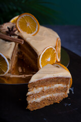 Cutaway orange cake with cream on a dark background