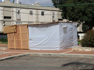 Sukkah for Sukkot from wooden sides and sheets on the street