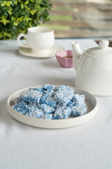 Blue candies with coconut on a light plate