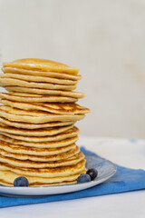 Bright yellow pancakes on a blue napkin. Big stack of pancakes