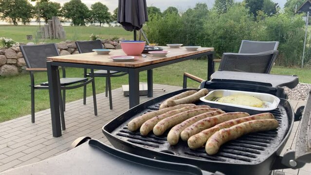 Barbecue, sausages and cheese and view to a table on a terrace with lake view 