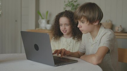 Happy joyful teenagers siblings playing games on laptop, brother and sister having fun together, mum coming and finishing interrupting, putting books and notes on the table. Time to study for children - Powered by Adobe
