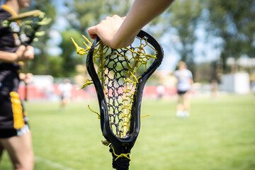 Lacrosse Themed Photo, American Sports. Female lacrosse player holding a lacrosse stick.