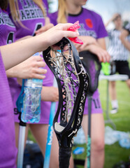 Lacrosse Themed Photo, American Sports. Female lacrosse player holding a lacrosse stick.