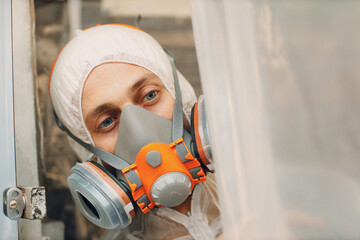 Car painter portrait in protective clothes and respirator mask painting vehicle - 752555713