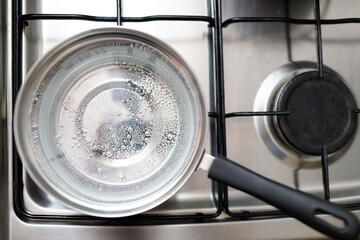 Saucepan stainless steel with boiling water on a gas stove. - 752556199