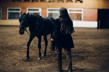 Young woman in black runs to her horse at ranch - 752556965