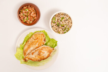 Grilled chicken in a plate with rice and beans isolated clean white background top view photo