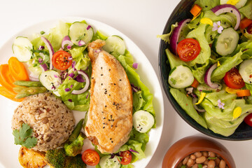 Grilled chicken in a plate with salad and rice isolated clean white background top view photo