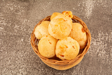 Brazilian cheese bread isolated inside a wooden basket in dark background in aerial top view