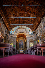 Perspective of benches inside the Our Lady of Amparo church with altar in the background, Válega -...