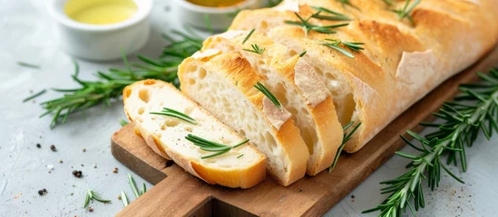Crédence de cuisine en verre imprimé Pain Freshly baked loaf of bread with a sprig of rosemary on a wooden cutting board