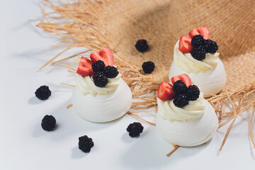 Dessert with berries on a meringue with cream.